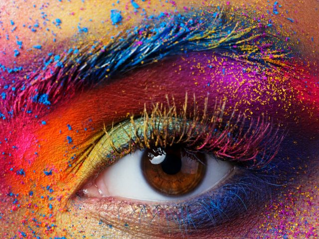Close up view of female eye with bright multicolored fashion mak