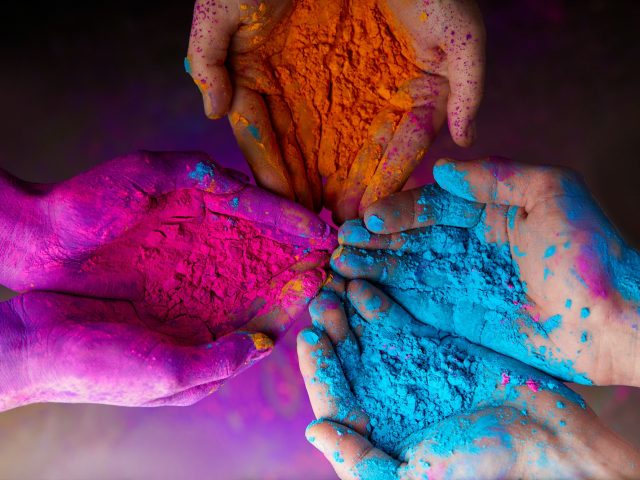 cropped view of hands with holi powder for Hindu spring festival of colours