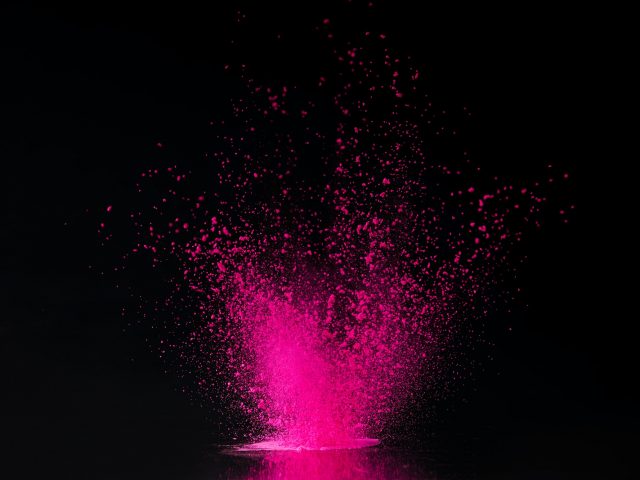 pink holi powder explosion on black, traditional Indian festival of colours